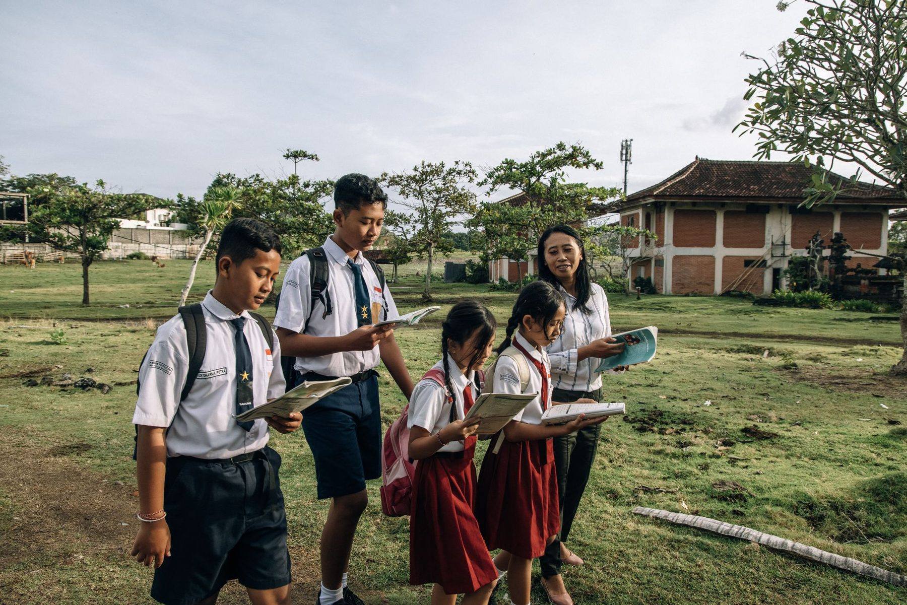 Siswa SD dan SMP berjalan bersama di lapangan sekolah